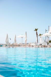 荷兹利亚丹尼尔荷兹利亚酒店的一个带白色椅子和遮阳伞的游泳池