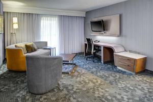 韦斯特莱克Courtyard by Marriott Cleveland Westlake的酒店客房配有一张床、一张书桌和一台电视。
