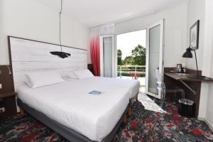拉罗谢尔拉罗谢尔中心基里雅德酒店的配有一张床、一张书桌和一扇窗户的酒店客房