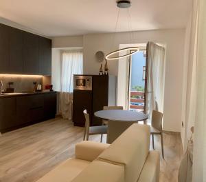 加尔达湖滨San Rocco Apartments的客厅以及带桌子和沙发的厨房。