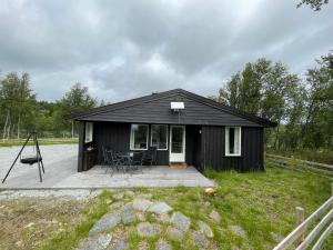 奥尔Sigurdhytta的一间黑色小小屋,设有木制甲板