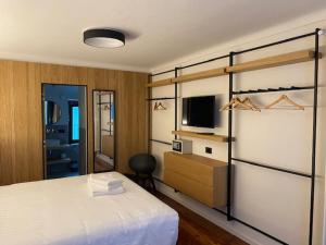 GhigoHotel SALEI的一间卧室配有一张床和一台电视。