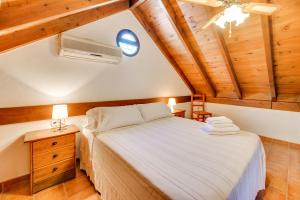 奥亨Casa rural entre Ojén y Marbella的一间卧室设有一张床,天花板设有木制天花板