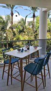 埃拉特Garden and Pool at Royal Park Eilat的棕榈树阳台的桌椅