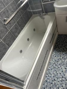 伦敦Home from Home的卫生间旁的浴室设有白色浴缸。