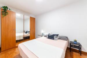 阿尔么丽亚Casa Maruchi - Apartamento的卧室配有一张白色大床和镜子
