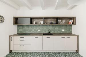 卡洛福泰AltaMarea - Ampi spazi in Centro storico的厨房配有白色橱柜和水槽