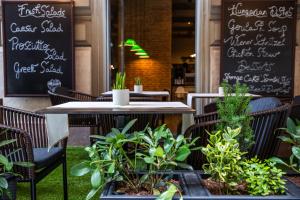布达佩斯艾斯提罗布达佩斯时尚酒店的一间设有桌椅和植物的餐厅