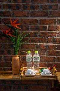 会安Hoi An Golden Bamboo An Bang Beach Villa & Spa的砖墙旁边的桌子上放两瓶水