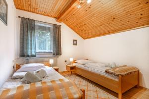 GrahovoHouse Mavko Near Lake Cerknica的配有木天花板的客房内的两张床