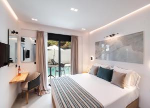 雷夫卡达镇Solvio Boutique Hotel & Spa的一间卧室配有一张床、一张桌子和一张桌子