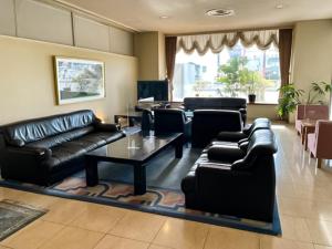 IchiharaIchihara Marine Hotel - Vacation STAY 01369v的客厅配有黑色真皮沙发和桌子