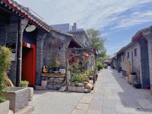 北京The East Hotel-Very close to the Drum Tower,The Lama Temple,Houhai Bar Street,and the Forbidden City,There are many old Beijing hutongs around the hotel Experience the culture of old Beijing hutongs,Near Exit A of Shichahai on Metro Line 8的一条街道,有一堆建筑和盆栽植物