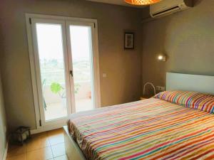埃勒凡达尔Villa Service - Coral III的一间卧室设有一张床和一个大窗户