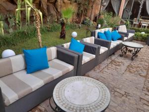 马拉喀什帝豪假日Spa酒店的一排长椅和一张带蓝色枕头的桌子