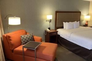 圣安Wingate by Wyndham St Louis Airport的酒店的客房 - 带一张床、椅子和电话