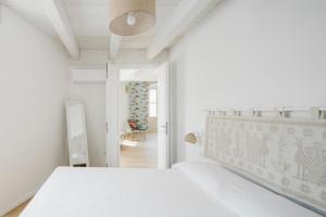 卡洛福泰AltaMarea - Ampi spazi in Centro storico的一间白色卧室,配有一张床和一个走廊