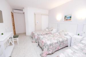 巴塞罗那拉莫斯旅馆的白色的客房配有两张床和一张书桌