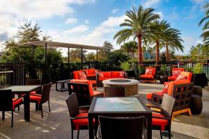 奥兰多万豪奥兰多诺娜湖万怡酒店的一个带桌椅的户外庭院,棕榈树