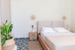 科斯镇Kosnian City Suites B的一间卧室配有一张床和盆栽植物
