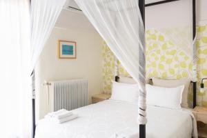 奥林匹亚达德国酒店的一间卧室配有两张床和一张天蓬床。