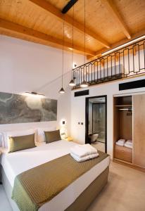 雷夫卡达镇Solvio Boutique Hotel & Spa的一间带大床的卧室和一个阁楼