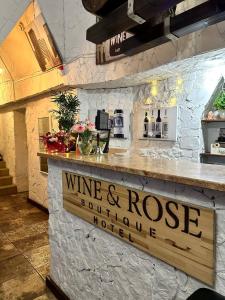 哈尔科夫WINE & ROSE BOUTIQUE HOTEL的酒和烤台,配以葡萄酒和玫瑰花标志