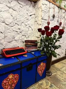 哈尔科夫WINE & ROSE BOUTIQUE HOTEL的一件蓝色的梳妆台,上面有玫瑰花瓶和书籍