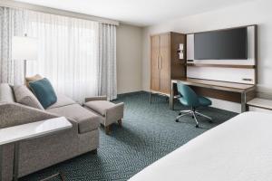 奥兰多奥兰多市中心万豪万怡酒店的酒店客房设有沙发、书桌和电脑