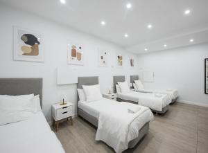 巴塞罗那巴塞罗那中心无限旅舍的白色墙壁的客房内的三张床