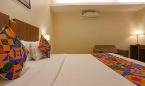孟买FabHotel Royal Mumbai International Airport的酒店客房配有一张带彩色枕头的大床