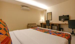 孟买FabHotel Royal Mumbai International Airport的酒店客房配有一张床、一张书桌和一台电视。