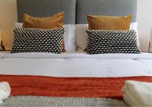 伯明翰Modern Spark Home with parking, garden, Wi-Fi的一张带四个枕头和白色床单的床