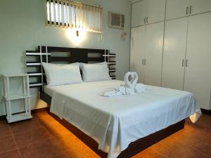 邦劳DMC2 Residence Panglao的卧室配有白色的床铺和白色的毯子