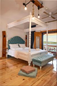 阿莫利亚尼岛Ammou Area的一间卧室设有一张天蓬床和木地板。