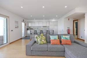 拉戈斯B19 - Marina Bay Apartment的一间带灰色沙发的客厅和一间厨房