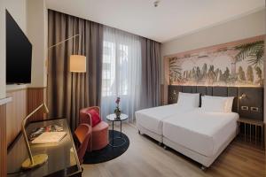 米兰NH Collection Milano Touring的酒店客房,配有白色的床和椅子