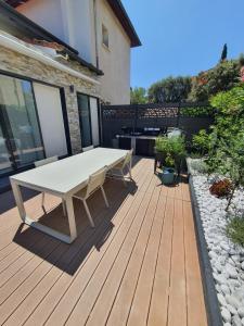 弗雷瑞斯Villa Daniel Saint Aygulf的木制甲板上配有白色桌子的庭院