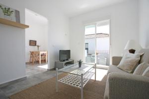 洛斯卡尼奥斯德梅卡卡伦卡萨斯公寓的带沙发和电视的白色客厅