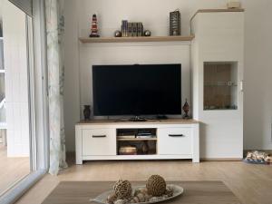 甘迪亚海滩Bonito y coqueto apartamento a 150metros de la playa 2 Línea的一间客厅,客厅内配有一台电视,位于白色娱乐中心