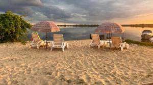 米兹多洛杰Lawendowa Przystań WICKO 3 km od Międzyzdrojów的海滩上的一组椅子和遮阳伞