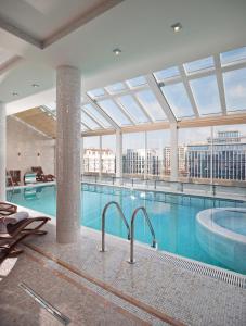 敖德萨布里斯托尔酒店的一座大型游泳池,位于一座带大窗户的建筑内
