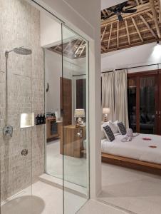 RuaUmarato Villa Sumba的一间卧室设有一张床和一个玻璃淋浴间