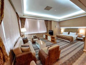 巴库Graaf Hotel的酒店客房配有一张床、一张沙发和椅子。