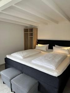 拉恩河畔林堡Hotel B4的卧室内的一张大床,旁边设有长凳