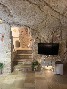 奥斯图尼Grotta Carlotta的楼梯间内配有电视的石墙