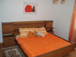 扎顿Apartment Josipa的一间卧室配有带橙色床单和枕头的床。