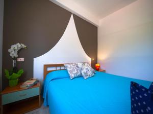 里卡迪Residence Olimpo的一间卧室配有一张带蓝色毯子的床