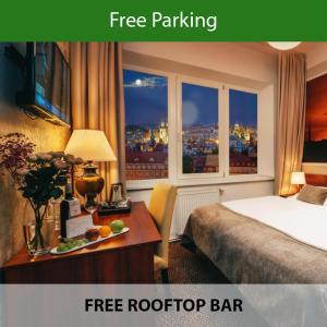 布拉格Metropolitan Old Town Hotel - Czech Leading Hotels的配有一张床、一张书桌和一扇窗户的酒店客房