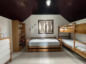 巴纳内拉斯Chalé no Condomínio Serra Nevada I的一间卧室设有两张双层床和一扇窗户。